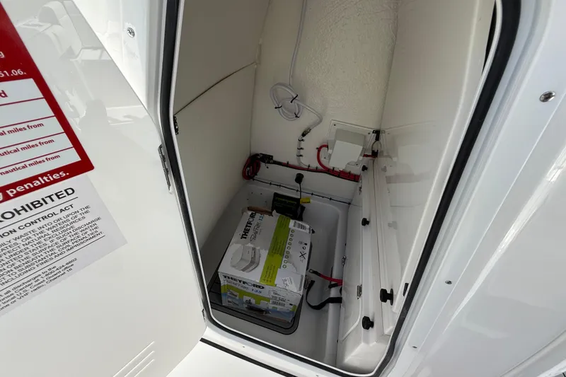 Slide: The Image of 2026 Tidewater 232 LXF boat storage compartment with battery and wiring. - 32