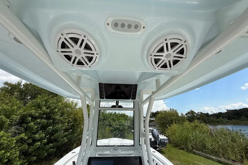 Slide: The Image of 2026 Tidewater 232 LXF boat with overhead speakers and control panel, scenic outdoor view. - 37