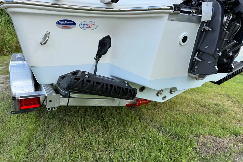 Slide: The Image of 2026 Tidewater 232 LXF boat on trailer, rear view, grassy background. - 39