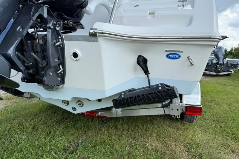 Slide: The Image of 2026 Tidewater 232 LXF boat rear view, showcasing motor and trailer on grass. - 40