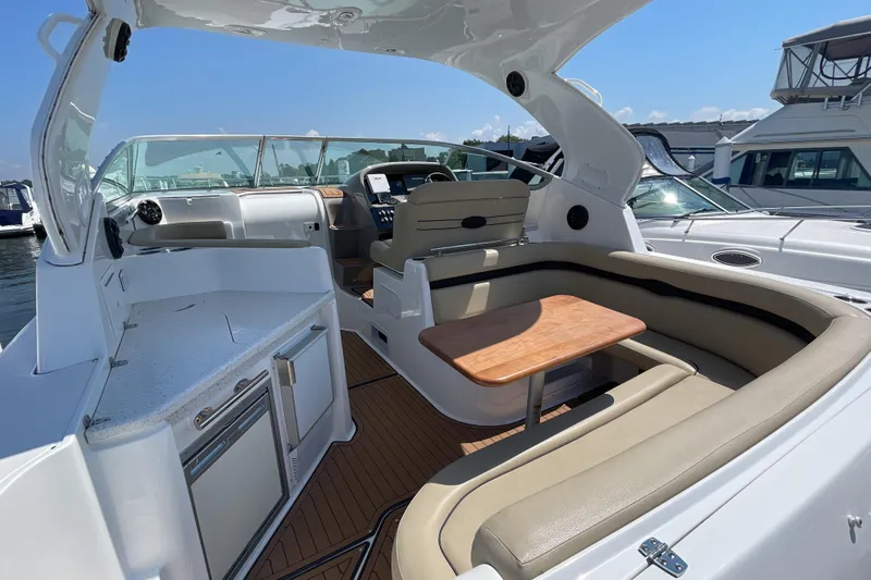 Slide: The Image of 2017 Rinker EX 370 boat interior with seating, table, and helm, docked at marina. - 10