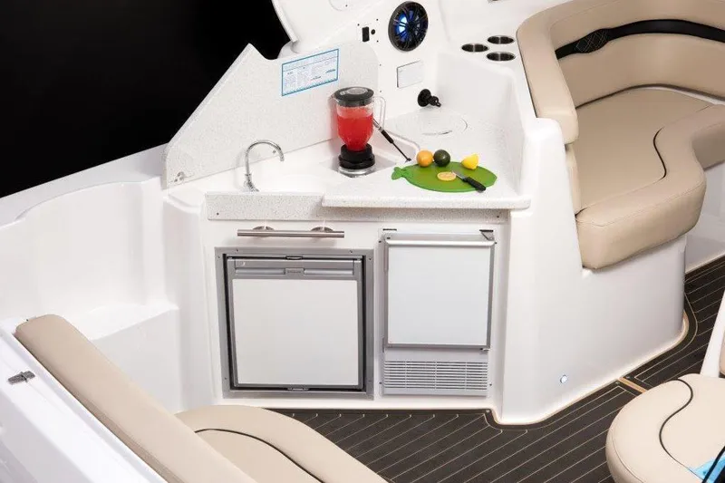 Slide: The Image of 2017 Rinker EX 370 boat interior with beige seating and wooden table at marina. - 13