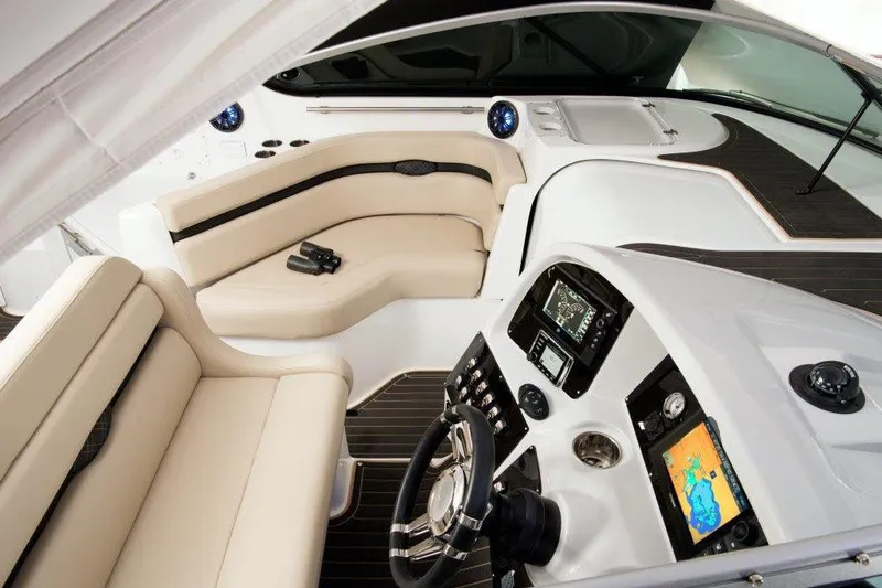 Slide: The Image of 2017 Rinker EX 370 boat interior with beige seating and helm, docked at marina. - 16