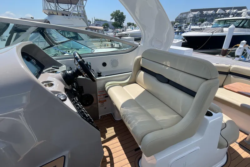 Slide: The Image of 2017 Rinker EX 370 boat interior with beige seating and modern dashboard. - 17