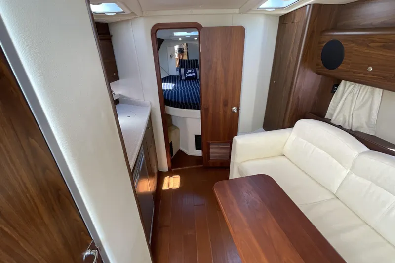 Slide: The Image of 2017 Rinker EX 370 yacht interior kitchen with microwave, sink, and wooden cabinetry. - 26