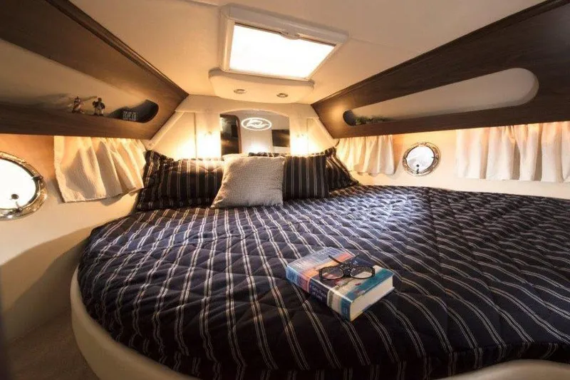 Slide: The Image of 2017 Rinker EX 370 boat bathroom with shower, toilet, sink, and porthole window. - 33