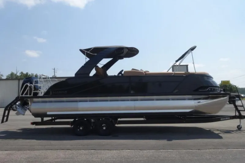 Slide: The Image of 2026 Harris Grand Mariner 250 pontoon boat on trailer, side view, outdoors. - 11