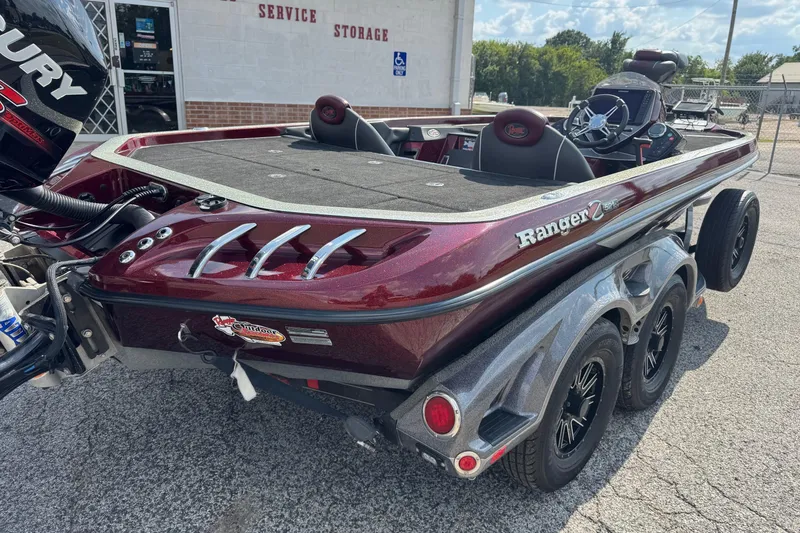 Slide: The Image of 2014 Ranger Z521 Comanche boat with Mercury engine, parked on a trailer in a service area. - 5