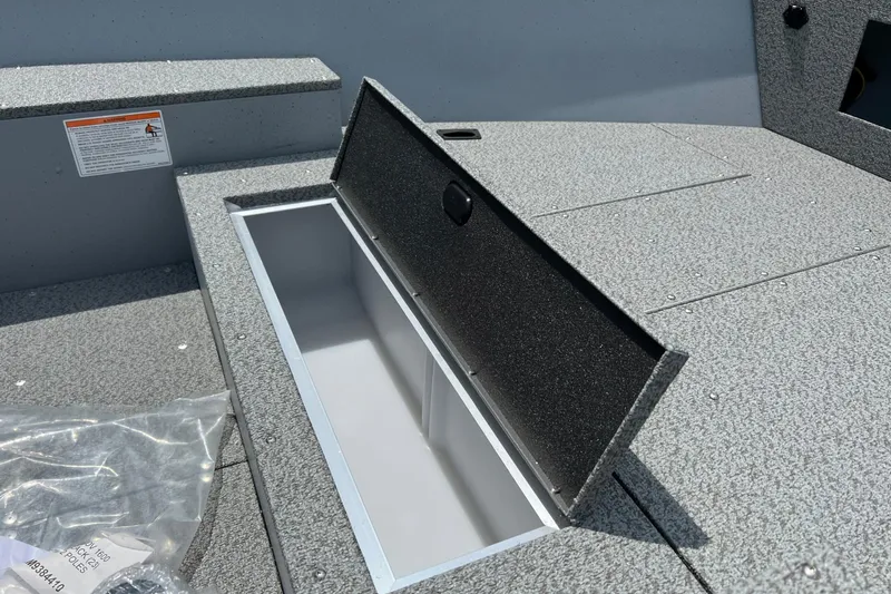 Slide: The Image of 2026 Lund 1600 Fury Tiller boat with open storage compartment, gray interior. - 10