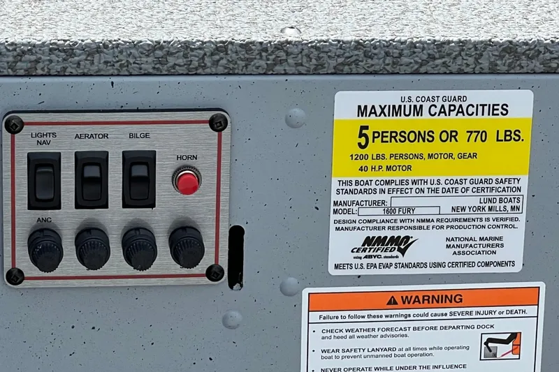 Slide: The Image of Control panel and capacity label on 2026 Lund 1600 Fury Tiller boat. - 11