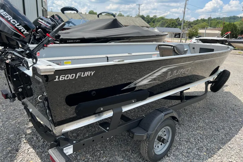 Slide: The Image of 2026 Lund 1600 Fury Tiller boat on trailer, featuring Mercury outboard motor. - 3