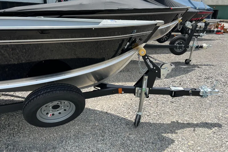 Slide: The Image of 2026 Lund 1600 Fury Tiller boat on trailer, parked on gravel. - 5