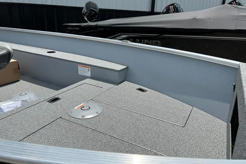 Slide: The Image of 2026 Lund 1600 Fury Tiller boat interior with storage compartments and seating. - 6