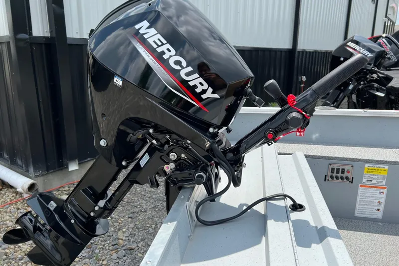 Slide: The Image of 2026 Lund 1600 Fury Tiller boat with Mercury outboard motor, parked outdoors. - 8