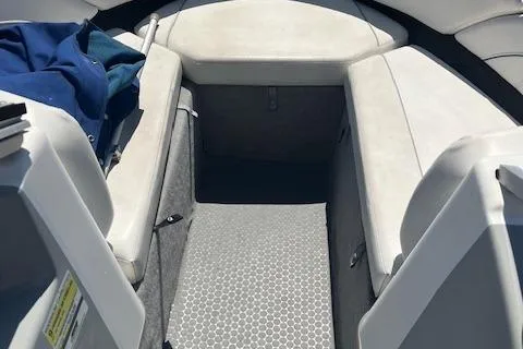 Slide: The Image of 2008 Bayliner 215 Discovery boat interior with cushioned seating and storage. - 5