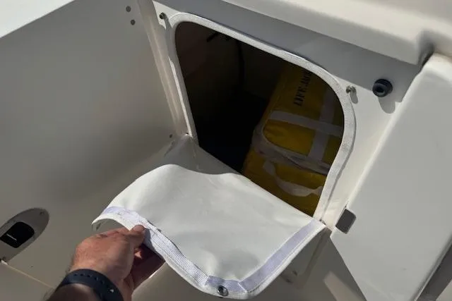 Slide: The Image of Storage compartment on a 2019 Robalo R207 Dual Console boat with safety equipment. - 17
