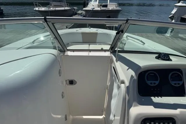 Slide: The Image of 2019 Robalo R207 Dual Console boat interior with dashboard and open water view. - 18