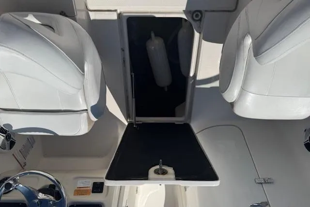 Slide: The Image of 2019 Robalo R207 Dual Console interior with storage compartment and white seating. - 19
