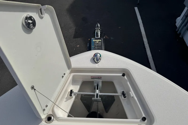 Slide: The Image of 2019 Robalo R207 Dual Console anchor compartment with open hatch, showcasing storage space. - 25