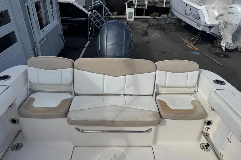 Slide: The Image of 2019 Robalo R207 Dual Console boat seating area with beige and white cushions. - 30
