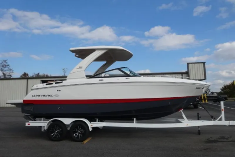 The Image of 2026 Chaparral 6 GTS boat on trailer, white and red design, parked outdoors. - 2