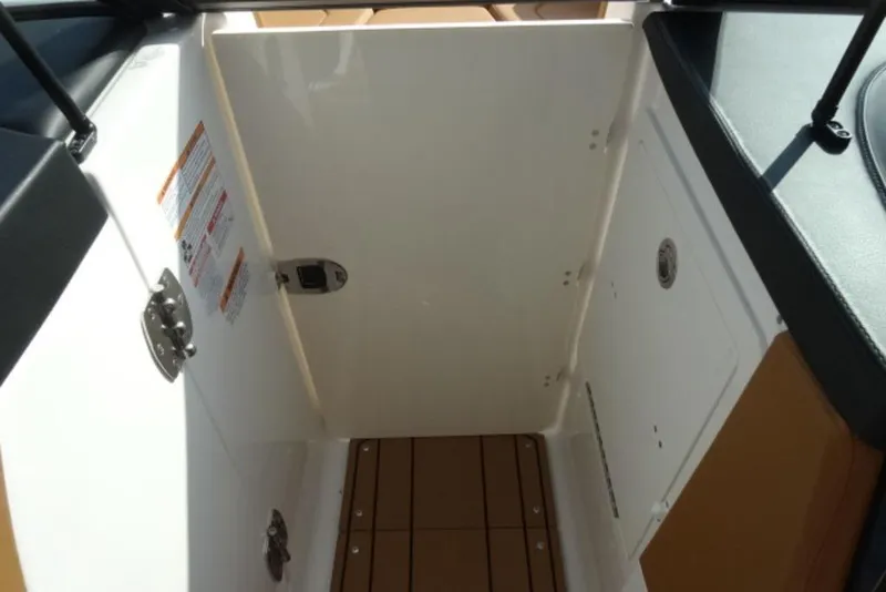 Slide: The Image of Interior view of 2026 Chaparral 6 GTS boat, featuring storage compartment and wooden flooring. - 24