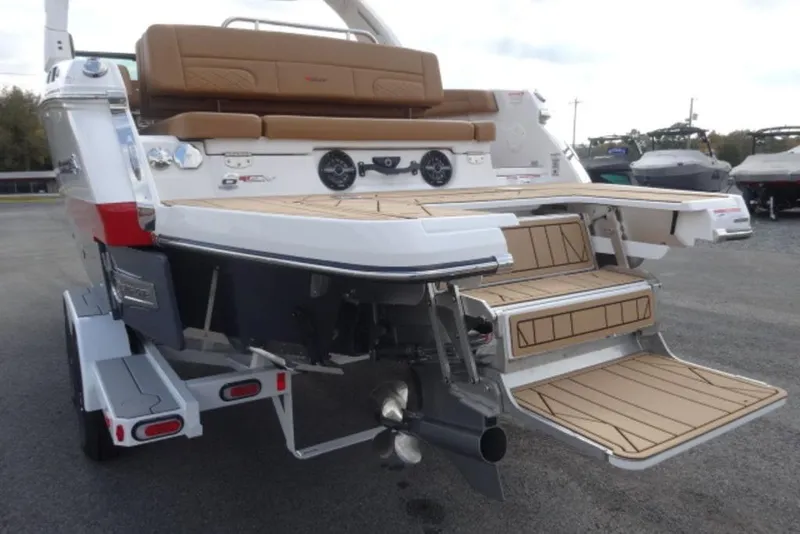 Slide: The Image of 2026 Chaparral 6 GTS boat with tan seating and swim platform, rear view. - 8