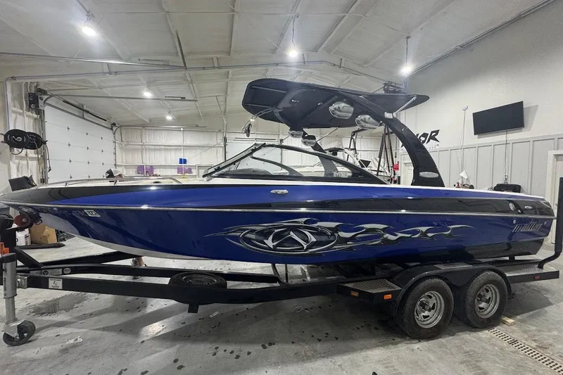 Slide: The Image of 2007 Malibu Wakesetter 23 LSV boat in a garage, blue with custom graphics. - 2