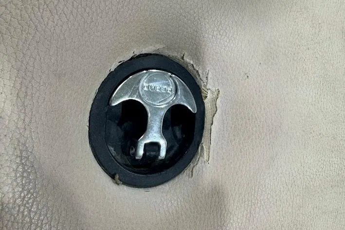 Slide: The Image of 2007 Malibu Wakesetter 23 LSV interior detail with a metal latch on beige upholstery. - 23