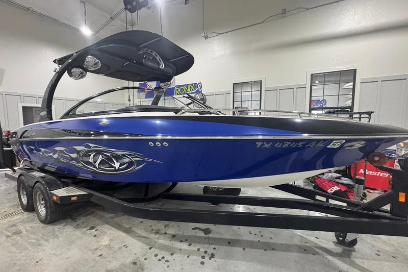 Slide: The Image of 2007 Malibu Wakesetter 23 LSV boat in a showroom, blue with custom graphics. - 28
