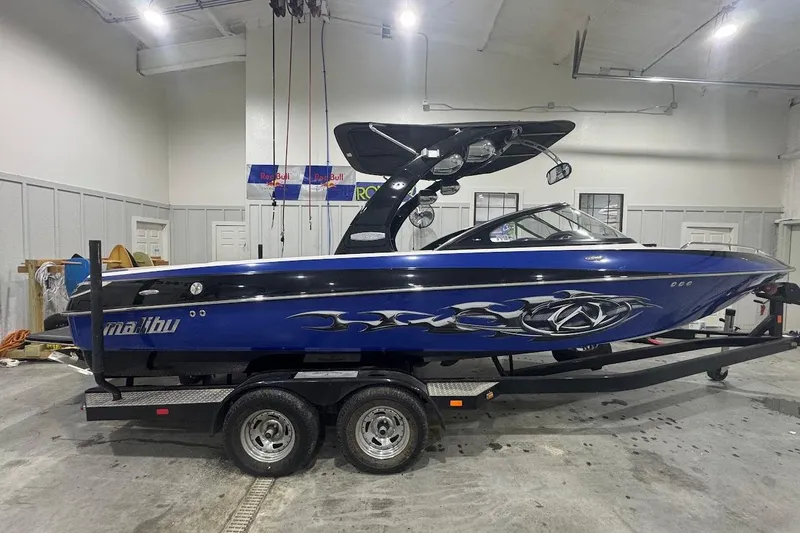 Slide: The Image of 2007 Malibu Wakesetter 23 LSV boat in a garage, blue with custom graphics. - 7