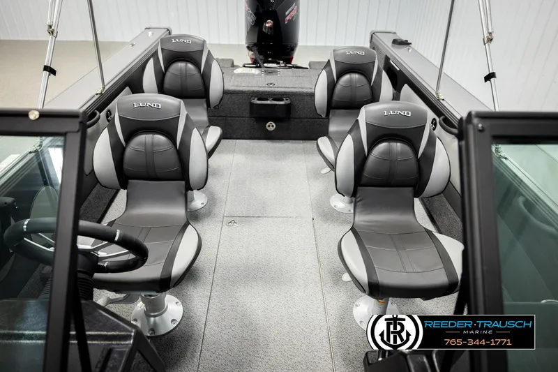 Slide: The Image of Interior of 2026 Lund 1975 Tyee boat with four gray seats and steering wheel. - 23