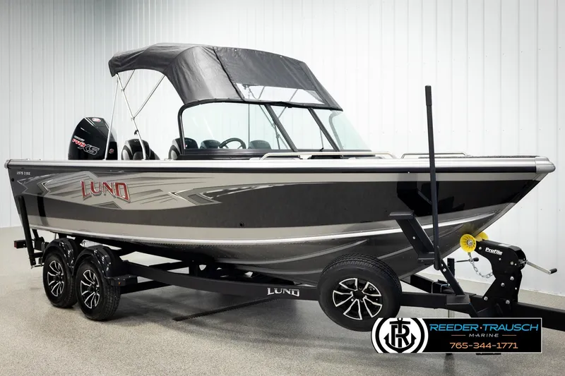 Slide: The Image of 2026 Lund 1975 Tyee boat with canopy on trailer, displayed indoors. - 3