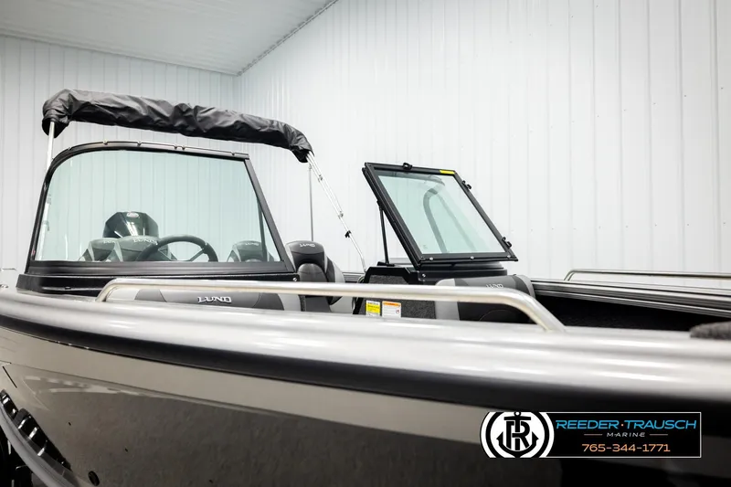 Slide: The Image of 2026 Lund 1975 Tyee boat in showroom, featuring sleek design and modern windshield. - 34