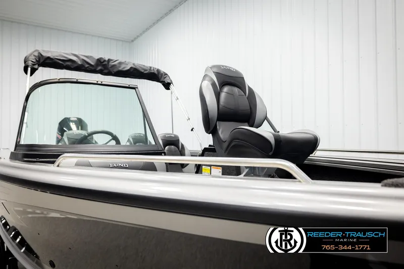 Slide: The Image of 2026 Lund 1975 Tyee boat interior with sleek seating and windshield, showcased indoors. - 35