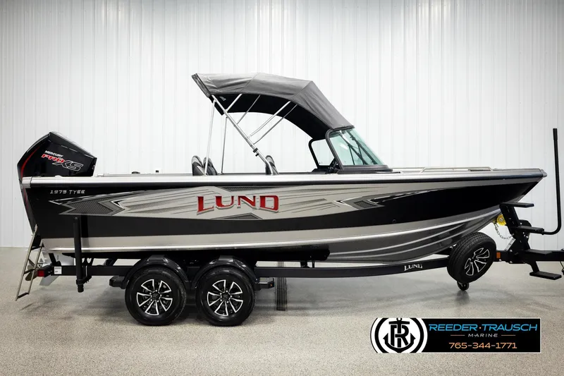 Slide: The Image of 2026 Lund 1975 Tyee boat with canopy on trailer, displayed indoors. - 4