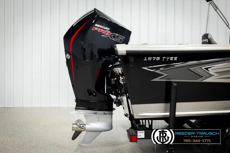 Slide: The Image of 2026 Lund 1975 Tyee boat with Mercury Pro XS outboard motor, displayed indoors. - 51