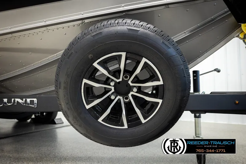 Slide: The Image of Close-up of a 2026 Lund 1975 Tyee boat trailer wheel with logo. - 57