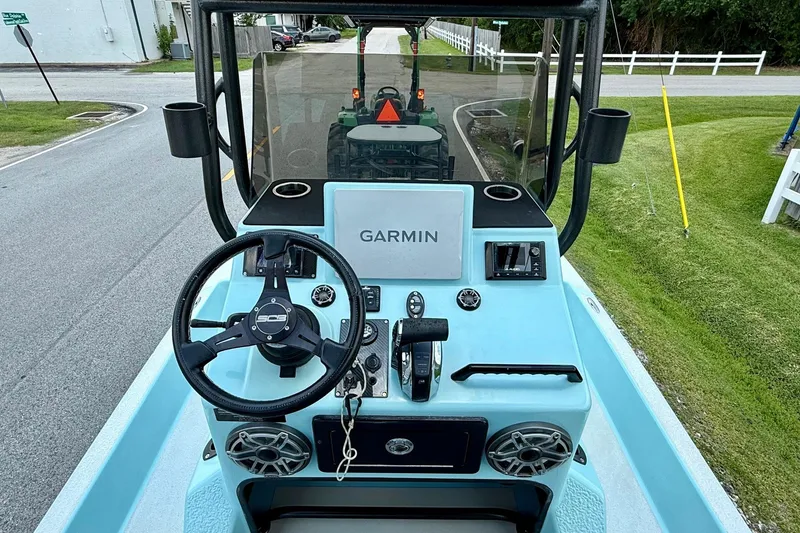 Slide: The Image of ```json
"SCB R24 boat dashboard with Garmin navigation, steering wheel, and controls, 2020 model."
``` - 10