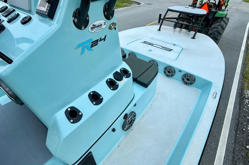 Slide: The Image of 2020 SCB R24 boat with light blue console and rod holders on a road. - 13