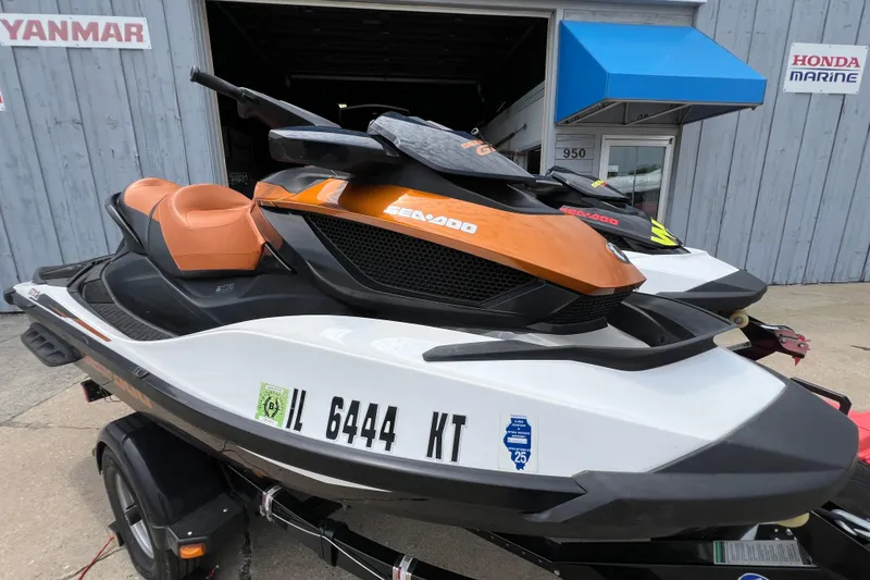Slide: The Image of 2015 Sea-Doo Wake Pro 215 jet ski with orange and white design on a trailer. - 13