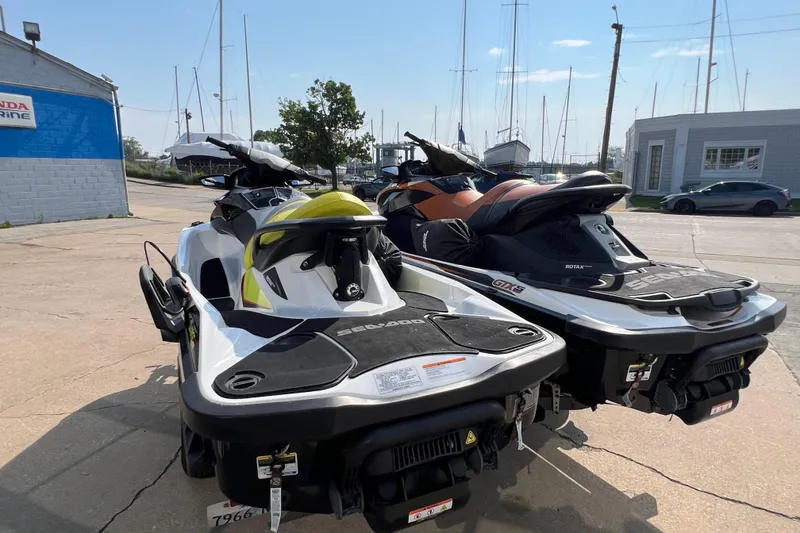 Slide: The Image of Two Sea-Doo jet skis, including a 2015 Wake Pro 215, parked at a marina. - 6