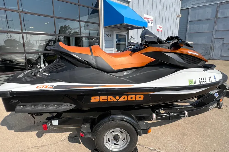 Slide: The Image of 2015 Sea-Doo Wake Pro 215 jet ski on trailer, parked outside dealership. - 8