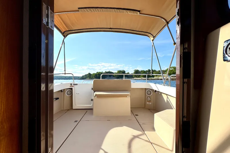 Slide: The Image of Interior view of 2012 Ranger 27 boat with canopy and scenic water backdrop. - 11