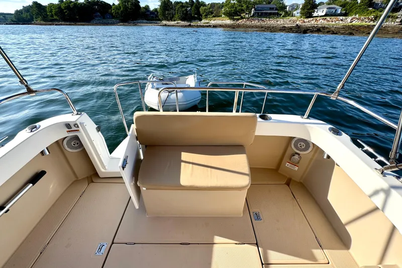 Slide: The Image of 2012 Ranger 27 boat interior with seating, overlooking calm waters and shoreline. - 13