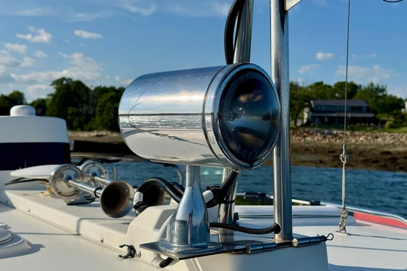 Slide: The Image of Close-up of a 2012 Ranger 27 boat spotlight and horn on deck, with scenic shoreline background. - 21