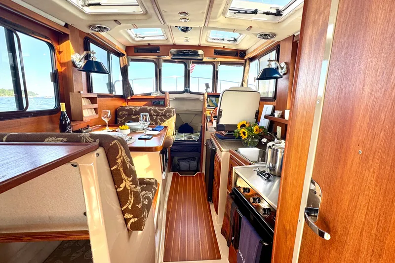 Slide: The Image of Cozy interior of 2012 Ranger 27 boat with dining area and kitchen amenities. - 23