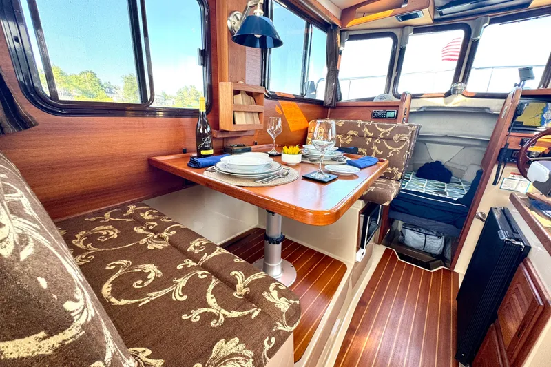Slide: The Image of Interior of 2012 Ranger 27 boat with elegant dining setup and wood finish. - 25