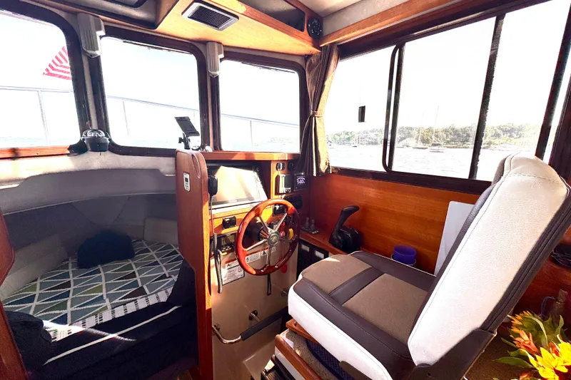 Slide: The Image of Interior of 2012 Ranger 27 boat with helm, seating, and cabin area. - 30