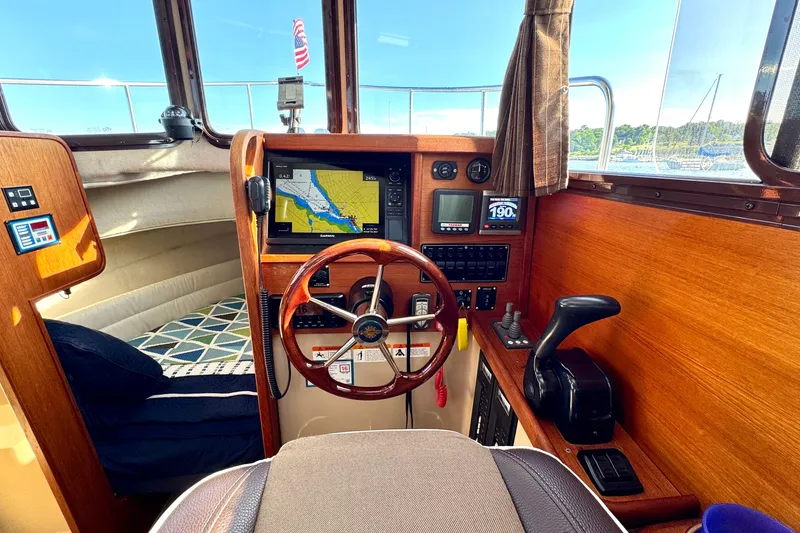 Slide: The Image of Interior of 2012 Ranger 27 boat with navigation equipment and wooden steering wheel. - 31